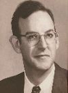 John Tucker: A black and white portrait of a man wearing glasses, a suit, and a tie, facing slightly to the left.