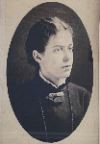 Stella Bullock: A black-and-white oval portrait of a young woman with dark hair pulled back, wearing a high-collared dress and a brooch.